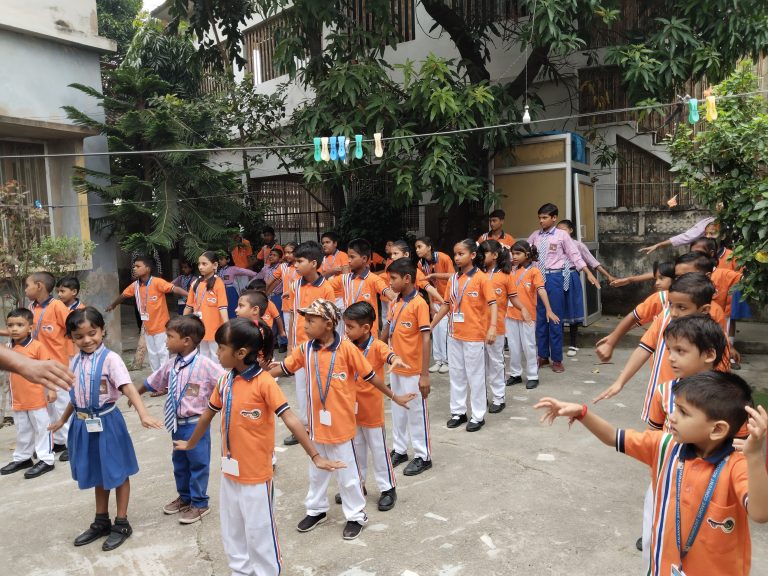 School children doing morning physical training outdoors